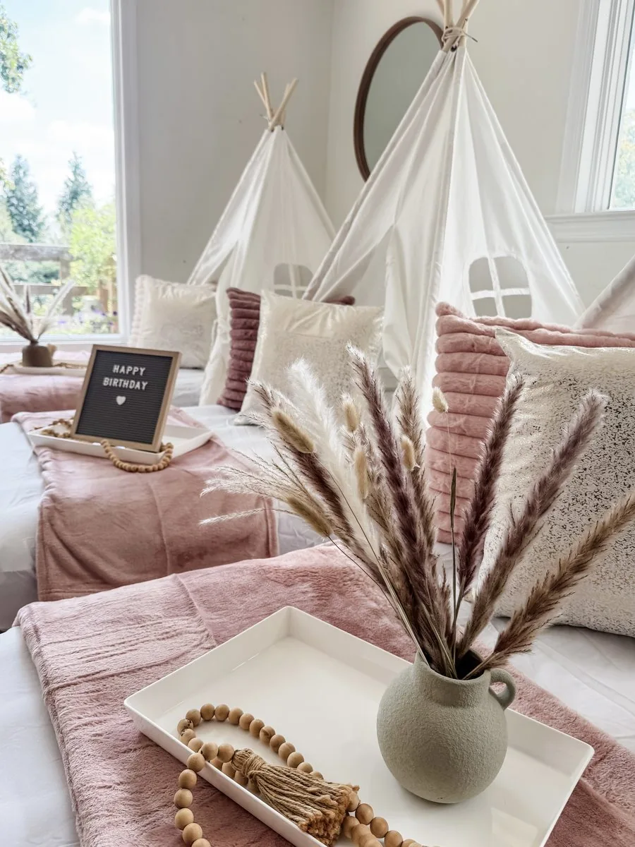Styled bed tray with a sage vase of pampas grass and a wood-bead garland on a blush teepee bed
