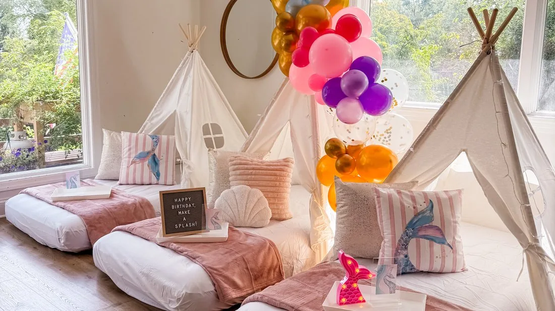 Row of white individual teepee tents set up for a sleepover party