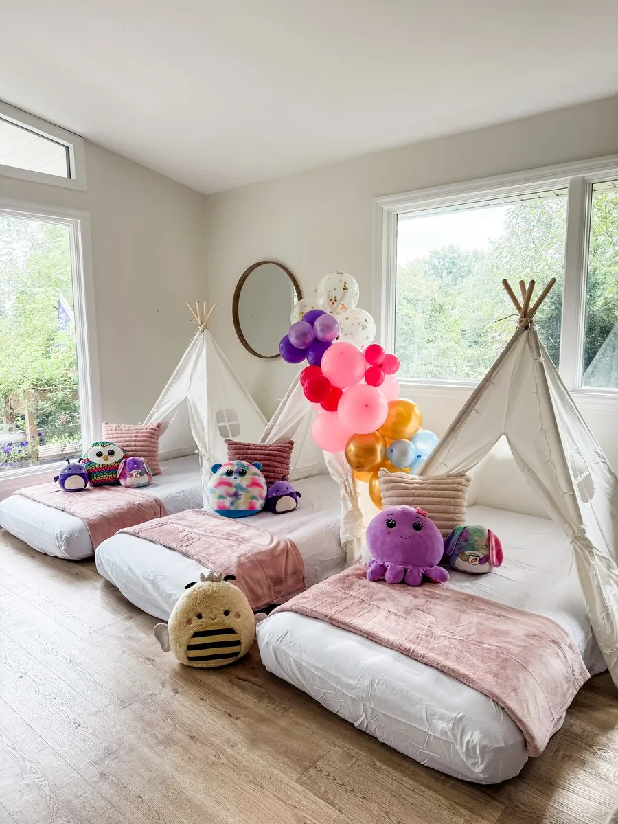 Five-foot balloon garland in pink, purple, and gold styled to match a sleepover theme
